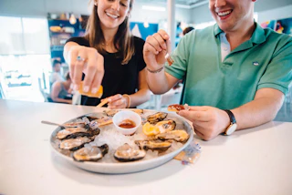 Couple enjoys raw oysters on the half shell at a restaurant in Baton Rouge